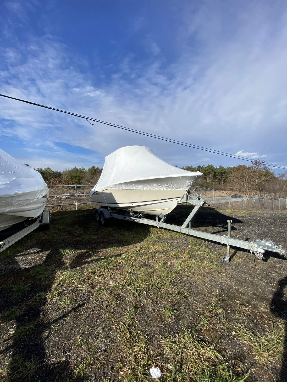 Shrink-wrapped boat on a trailer in the Boatworks outdoor storage yard