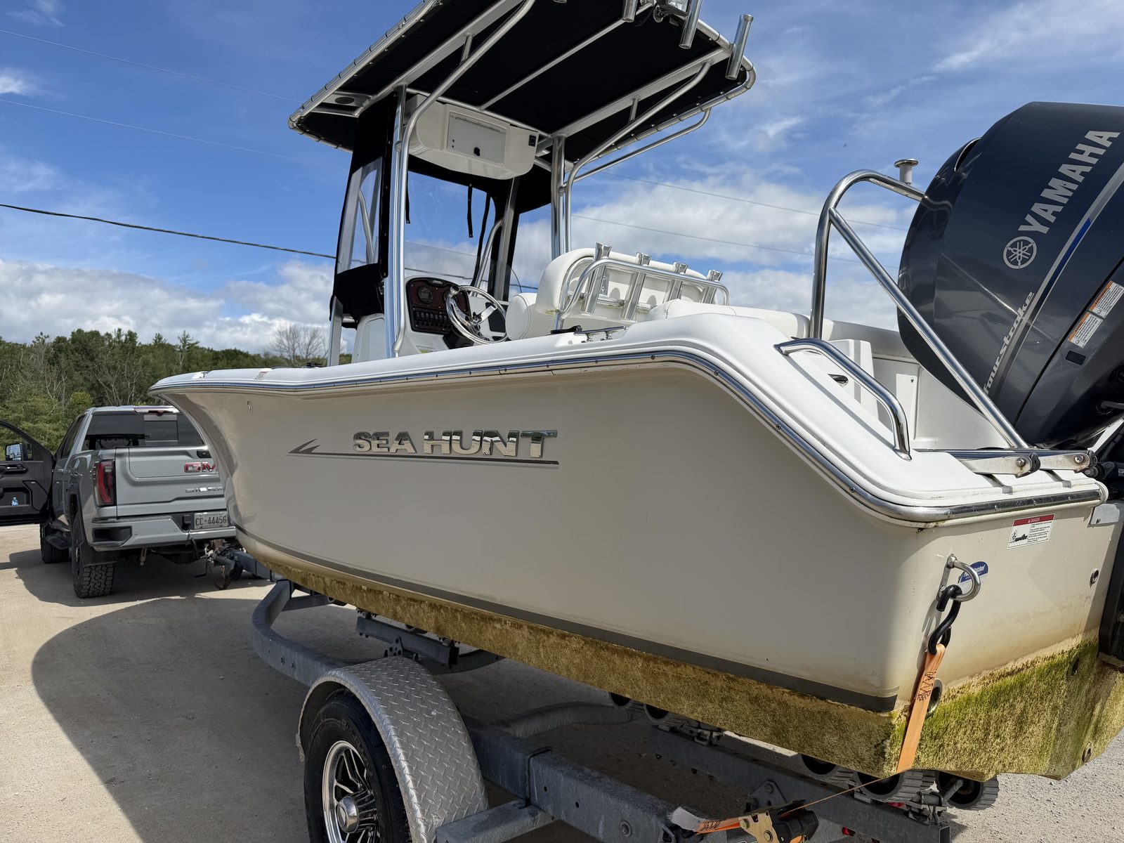 Sea Hunt center console with green algae and scum on the hull, before cleaning